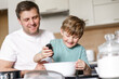 © alenaphoto - Dad and little son baking together in kitchen, preparing dough for pie, having fun at home, preparing a surprise for mom on mother's day