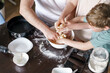 © alenaphoto - Hands only, dad and little daughter and son baking together in kitchen, preparing dough for pie, having fun at home during quarantine