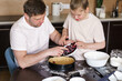 © alenaphoto - Dad and little daughter baking together in kitchen, preparing dough for pie, put the berries on the dough, having fun at home during quarantine