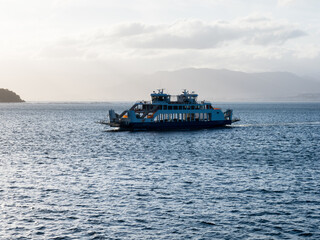 Wall Mural - Hiroshima, Japan - August 25, 2018: Ferry boat crossing the Seto Inland Sea at Hiroshima bay at sunset