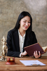 Business woman Lawyer office. Statue of Justice with scales and a Female lawyer working on a laptop gavel and femida at the workplace. Legal law, advice and justice concept.