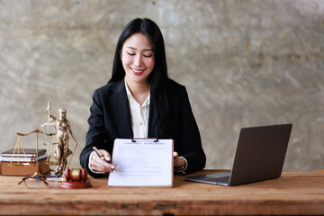 Wall Mural - Business woman Lawyer office. Statue of Justice with scales and a Female lawyer working on a laptop gavel and femida at the workplace. Legal law, advice and justice concept.