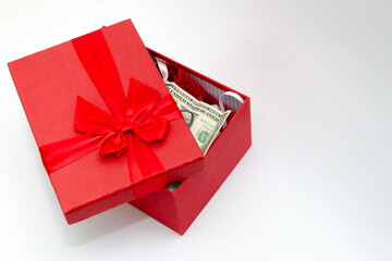 Wall Mural - Red gift box with a bow and dollar banknote on а white background