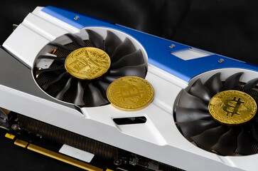 Video card (graphic card) with gold coins symbolizing bitcoin. Cryptocurrency mining concept. Close up. Dark background