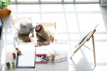 Wall Mural - Ariel view couple artist meeting and brainstorming for work on the table