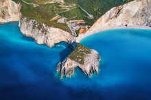 Aerial View Of Blue Sea, Mountains, White Sandy Beach At Sunrset In Summer. Porto Katsiki, Lefkada Island, Greece. Beautiful Landscape With Sea Coast, Yacht, Rocks, Azure Water, Green Forest. Top View