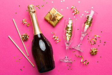Wall Mural - Bottle of champagne with colored glitter, confetti and gift box space for text on colorfull background, top view. Hilarious, christmas and birthday celebration