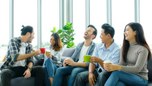 Group Of Happy Creative Team Talking While Taking Coffee Break At Office