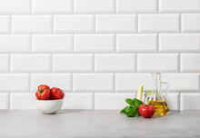Ripe Tomatoes Basil Garlic Bottle Of Oil On The Background Of A White Tiled Wall, Kitchen