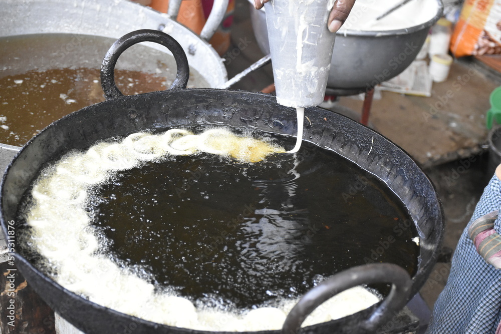 Indian male hand making Indian popular sweet dish Jalebi. Jalebi, also ...