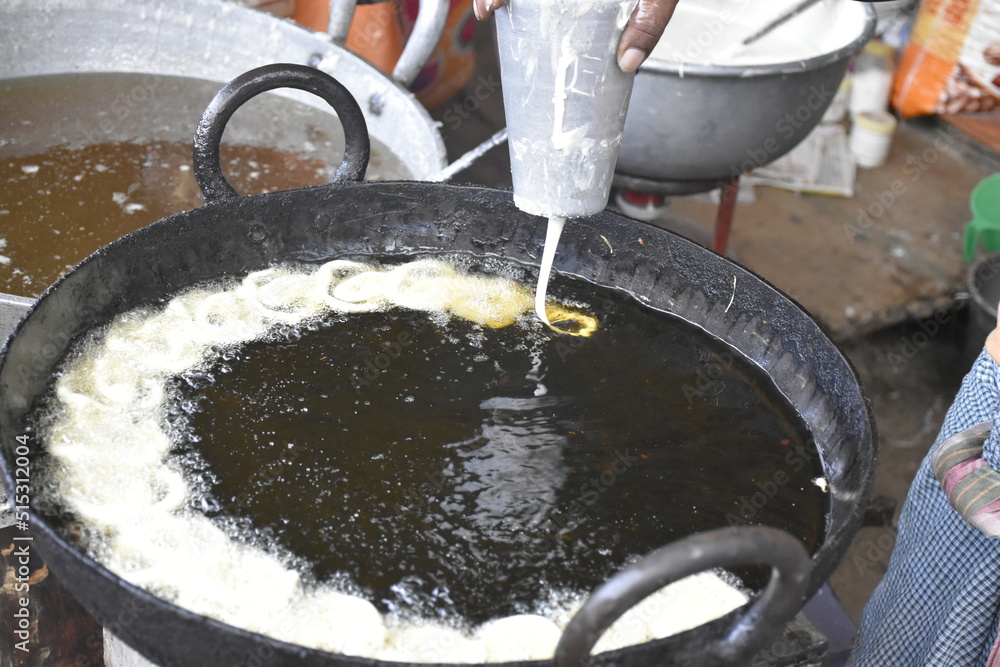 Indian male hand making Indian popular sweet dish Jalebi. Jalebi, also ...