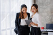 © David - Businesswoman executive is using a tablet in meeting discussion with another businesswoman or client in modern workplace office. People corporate Asian business people team concept.