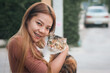 © witsawat - Asian woman holding a white cat. A woman hugging a cat for a walk in the garden. women love pet.