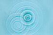 Blue water texture, surface with rings and ripples. Spa concept background. Flat lay, copy space.