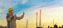 Engineer Manager Worker Speaking On Mobile Phone With Telecommunication Antenna And Sunset Background.