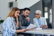 © bnenin - Side view of serious-looking people, dressed elegantly, working at the office.