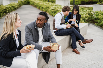 Multiethnic business people doing lunch break outdoor from office building - Focus on african man face