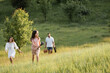 © LIGHTFIELD STUDIOS - happy child with lavender bouquet running in meadow near parents on blurred background.