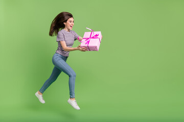 Poster - Full length profile portrait of excited pretty lady hold giftbox look empty space isolated on green color background