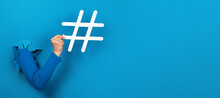 Hand Holding Hashtag Sign Over Blue Background, Social Media Concept, Panoramic Layout