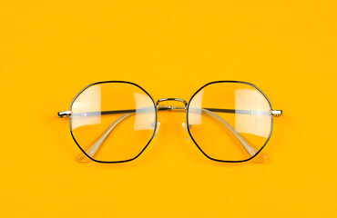 Stylish glasses in an iron black frame on an orange background