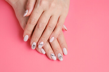 Wall Mural - Perfect artificial fingernails of adult woman on a pink background. Art painting of nails. Care for sensuality female hands. Shallow depth of field