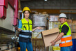 © kanpisut - African American worker working in warehouse. Industrial and industrial workers concept. worker woman order details and checking goods and Supplies.