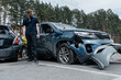 © Stanislav - Man stands near riddled with bullets car shot by the Russian army during the evacuation of civilians.