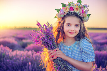 Wall Mural - Happy little girl with dress enjoying lavender field with bouquet of flowers