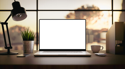Wall Mural - laptop with blank screen on table in livingroom during golden sunset or sunrise - home office backgr