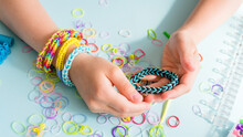 Loom Bracelets On Hand Of Little Girl. Long Banner Format. Closeup Of Making Decorative Bracelet With Elastic Bands