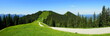weites Panorama von herrlichem Wandergebiet bei Bad Kohlgrub mit Berg, Wiesen, Weg und Wald bei blauem Himmel