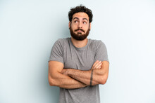 Young Adult Bearded Man Shrugging, Feeling Confused And Uncertain, Doubting With Arms Crossed And Puzzled Look