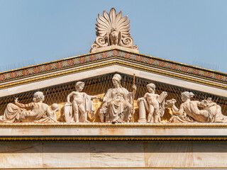 The east gable of the building of the National University of Athens, Greece. Athena, the goddess of wisdom and knowledge, sits on her throne with demigods and minor deities around and an owl on top.