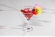 © bepsphoto - Red sweet cold party drink in elegant shot glass with ice cubes, strawberry and lime