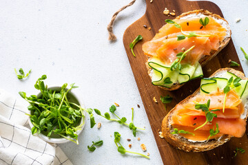 Sticker - Open sandwich with cream cheese, salmon and cucumber. Top view at white table.