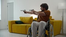 A Man In A Wheelchair Playing With Blank Guns