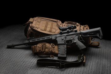Wall Mural - A modern automatic carbine with a collimator sight. The weapon lies on a military backpack. Rifle for the police, special forces or the army. Dark back.
