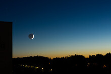Representation Of A Crescent Waxing Moon Setting On The Horizon During A Summer Evening