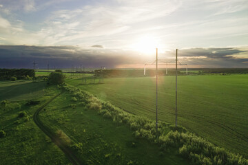 Wall Mural - High voltage power lines at the field at the sunset time