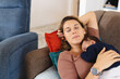 © Wavebreak Media - Caucasian mid adult mother napping with sleeping cute newborn baby on couch at home