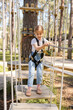 © Julija - Little girl overcomes the obstacle in the rope park. cute girl runs track, leisure on nature.