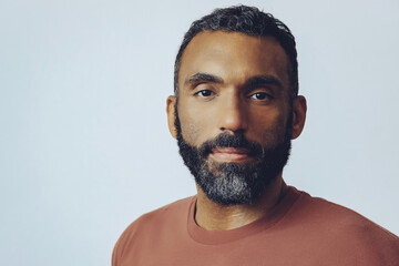 Wall Mural - headshot portrait of a handsome thoughtful bearded mid adult man looking at camera against gray background studio shot