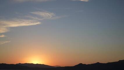 Wall Mural - sunset time in scenic landscape. 4k stock video footage of black silhouettes of several mountains, o