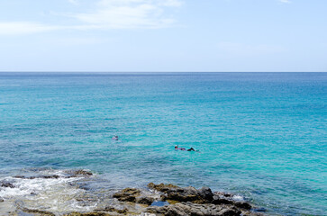 Two young sportsmen with mask and snorkel in the sea. couple snorkeling together in the mediterranean sea. two friends swimming with snorkels in canary islands.