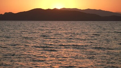 Wall Mural - beautiful peaceful sunset over sea and mountains. 4k stock video footage of beautiful sunny landscap