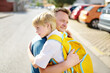 © Maria Sbytova - Little boy says goodbye and hugging to his father before going to school. Dad brought his son by car. Education for children. Child is a first day of school. Kids fear.