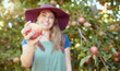 © Jade Maas/peopleimages.com - Young female farmer holding a freshly picked apple harvested herself in an orchard garden. Woman picking nutritious organic fruit for making juice, cider and vinegar on sustainable farm during summer
