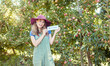 © Jade M/peopleimages.com - Female farmer recruiting workers to help with her startup. Happy young woman holding a hiring sign on a farm close to apple orchards. Farm labor shortage, agriculture job market and employment