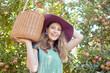 © Jade M/peopleimages.com - Portrait of a happy farmer holding a basket of freshly picked apples in an orchard outside on a sunny day. Cheerful woman harvesting and gathering juicy, nutritious and organic fruit in summer season